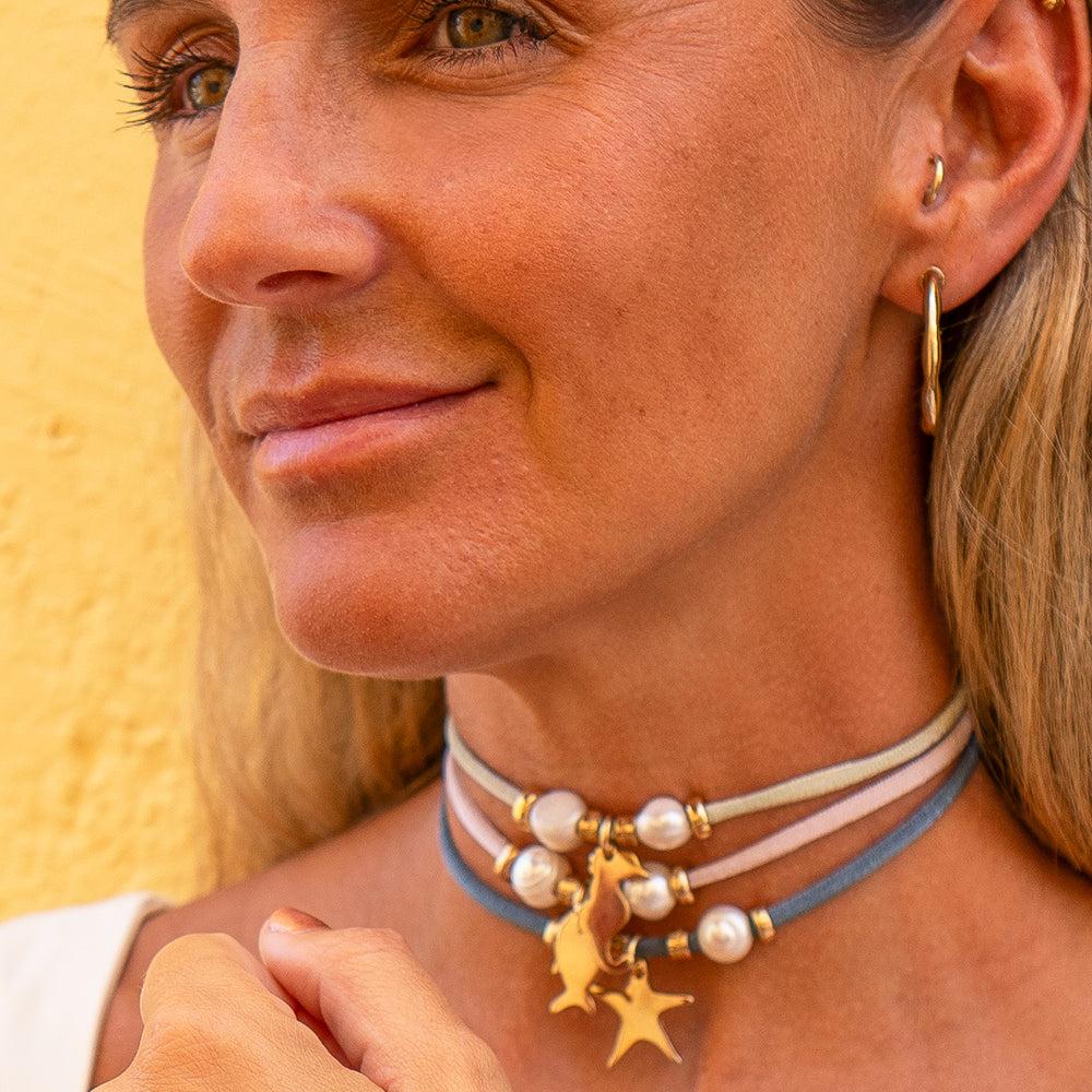 Collar de perlas y cintas azul y nude con charm dorado de unicornio, estilo bohemio y elegante.