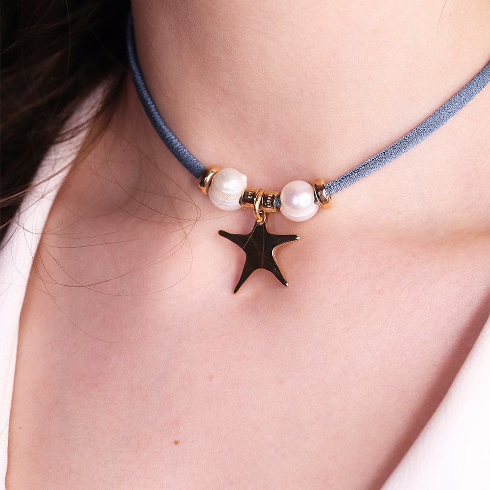 Collar de choker azul con perlas blancas y colgante estrella dorada. Elegante y moderno.