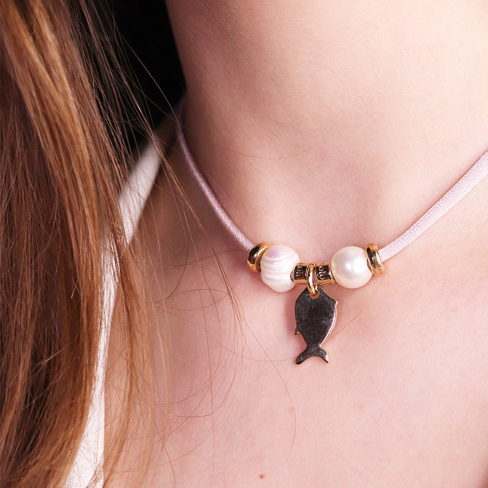 Collar rosa con perlas blancas y charm de pez plateado, estilo elegante y moderno, ideal para cualquier ocasión.
