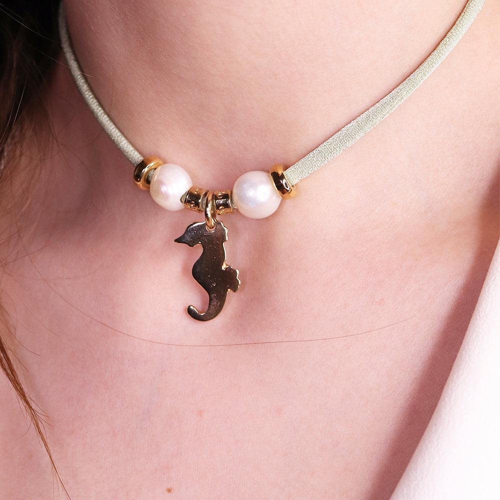 Collar de terciopelo verde claro con charm de caballito de mar y perlas blancas, estilo elegante y moderno.