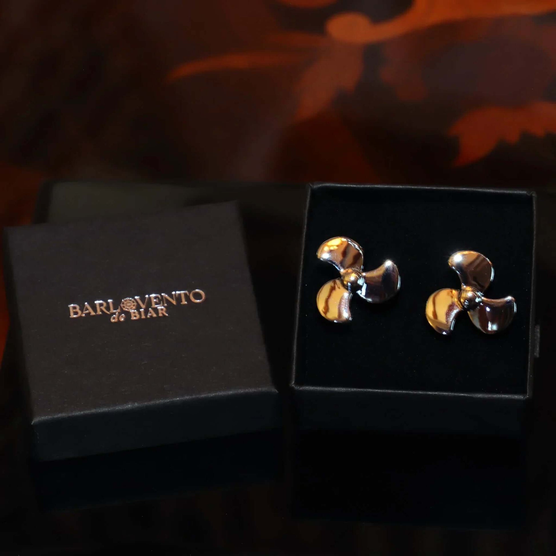 Gemelos con hélice de barco en una caja elegante, perfectos para amantes de la navegación.