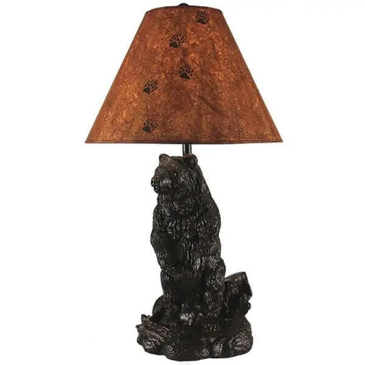 Rustic table lamp featuring a brown bear base and a textured shade decorated with black bear paw prints.