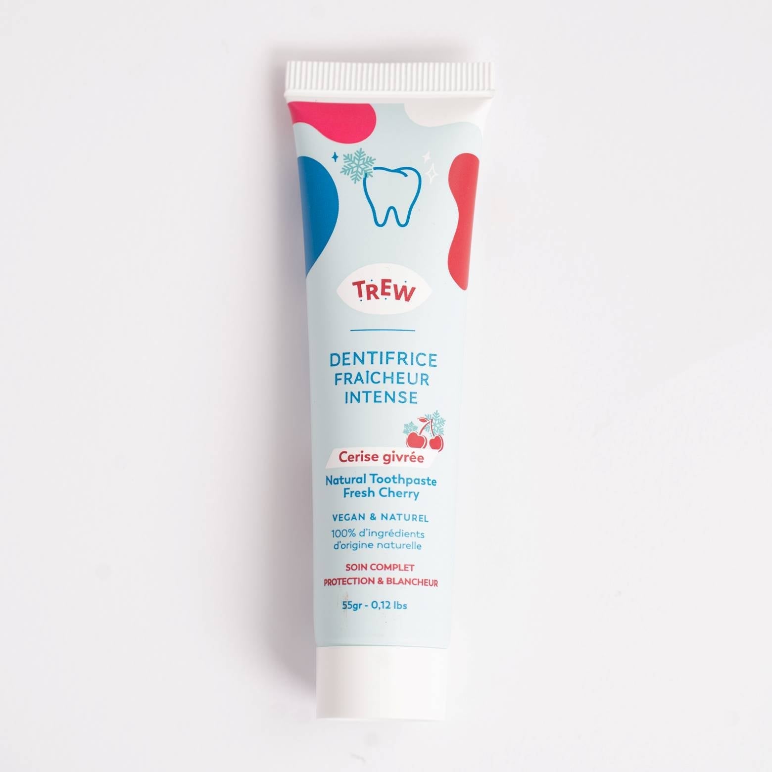Tube de dentifrice Trew bleu clair, motifs abstraits, logo dent et cerises givrées, sur fond blanc minimaliste.