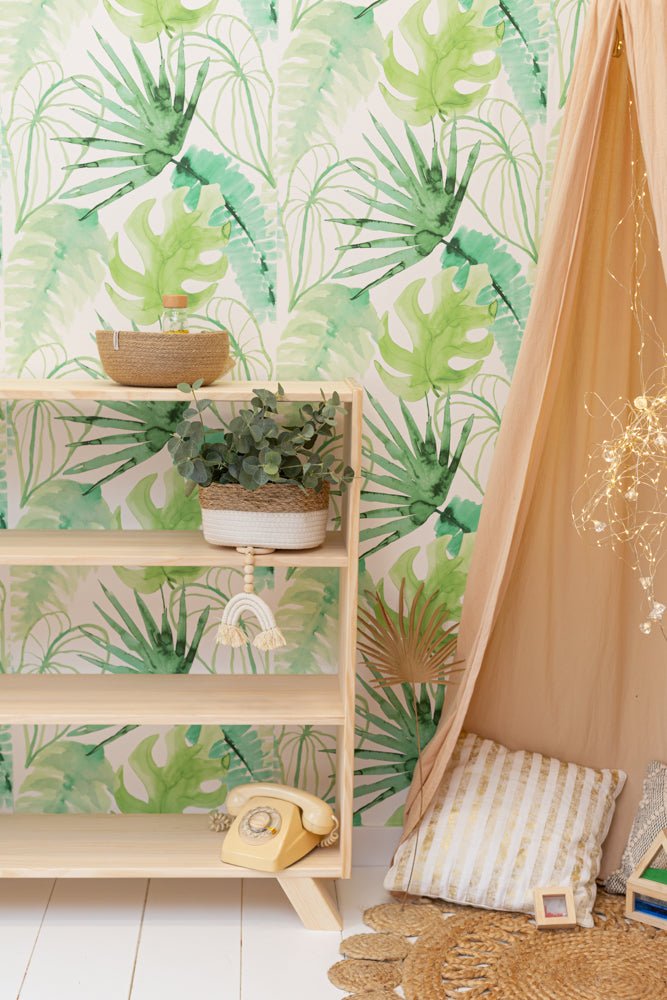 Estantería de madera clara con decoración de plantas verdes y cojines beige y blanco en un ambiente acogedor.