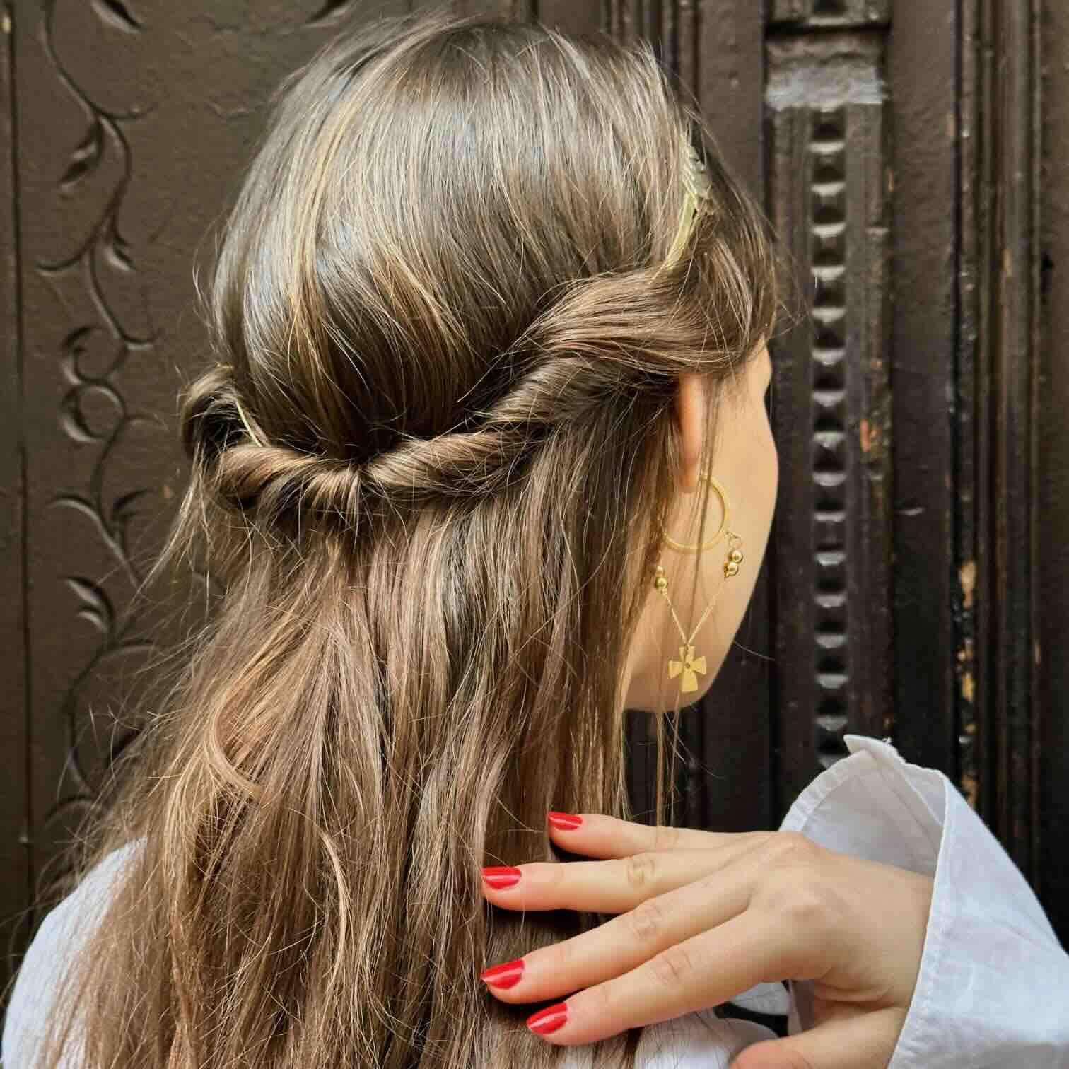 Peinado trenzado con cabello rubio y accesorios dorados; peinado elegante y romántico perfecto para cualquier ocasión.