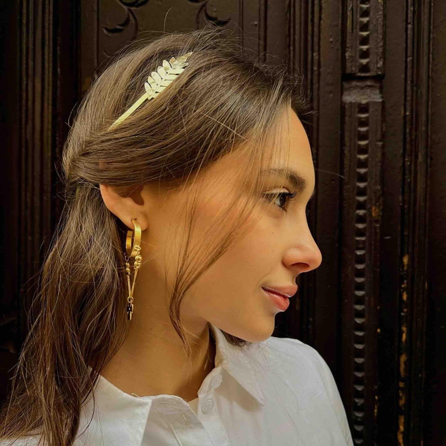 Diadema blanca con diseño de hoja, elaborada en metal, ideal para un estilo elegante y moderno.
