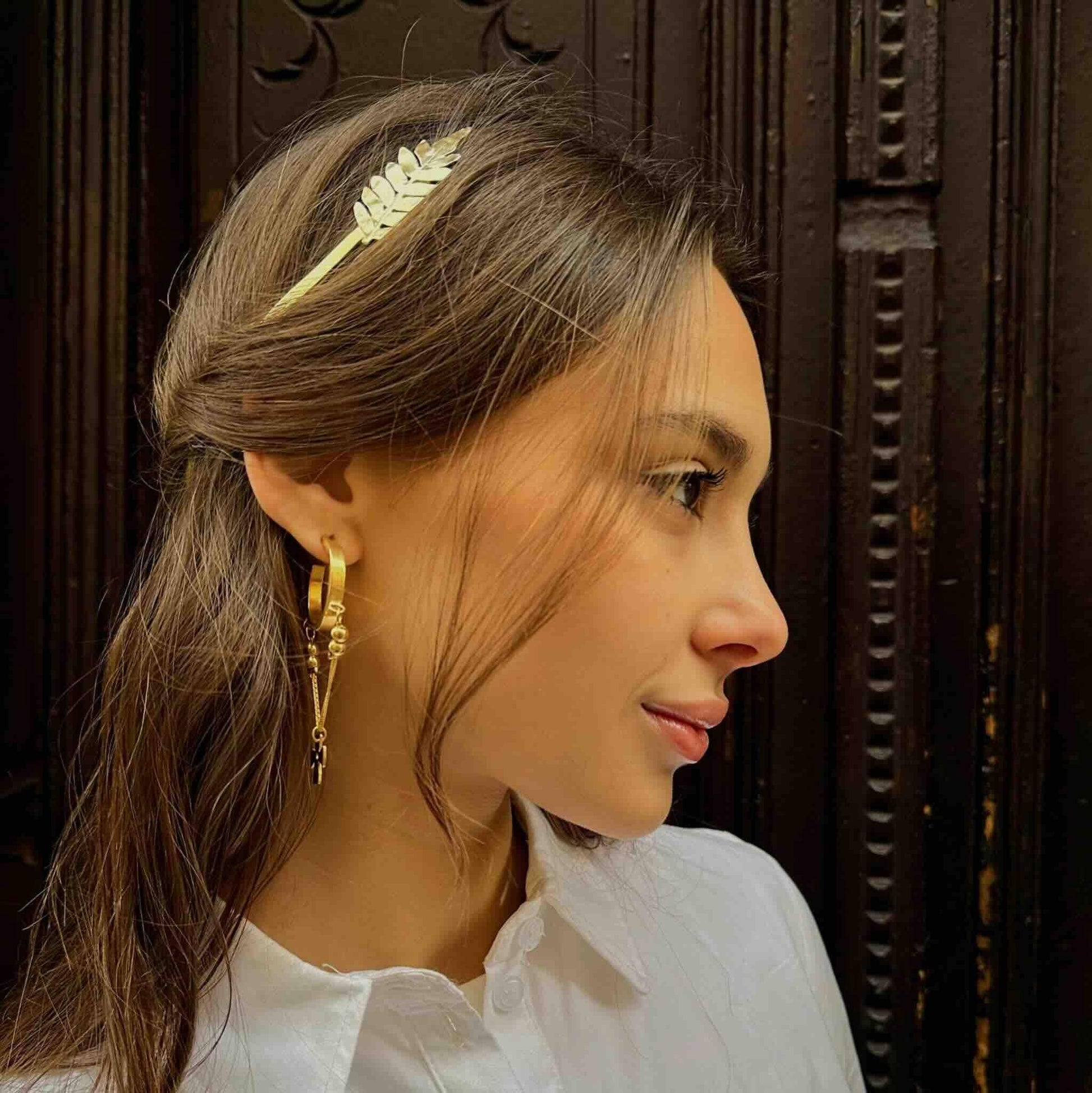 Diadema blanca con diseño de hoja, elaborada en metal, ideal para un estilo elegante y moderno.