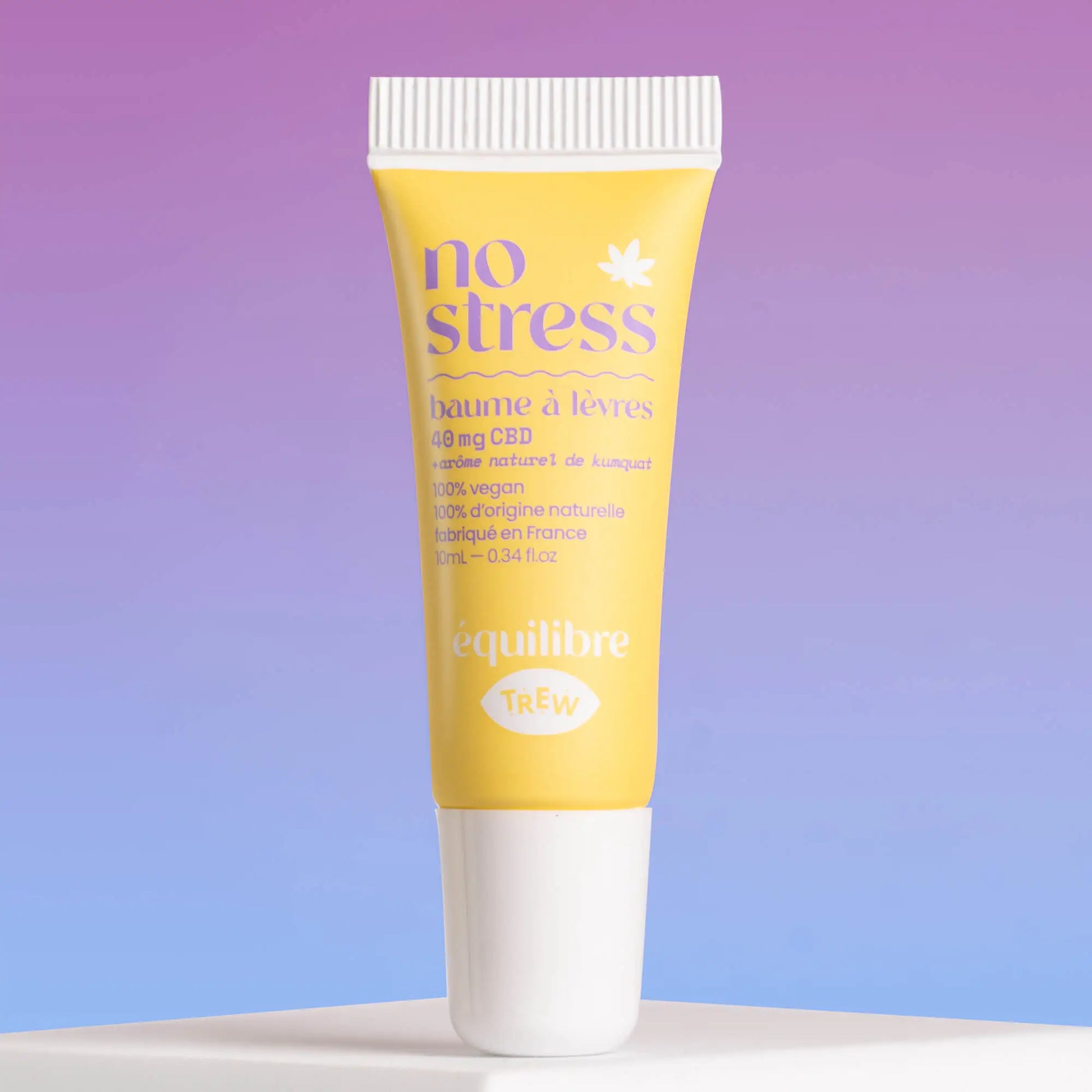 Yellow squeeze tube of CBD lip balm with "no stress" text, white cap, against a gradient purple and blue background.