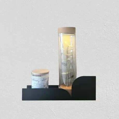 Estantería metálica flotante de pared Torino mediana en negro con objetos decorativos, vela aromática y lámpara LED