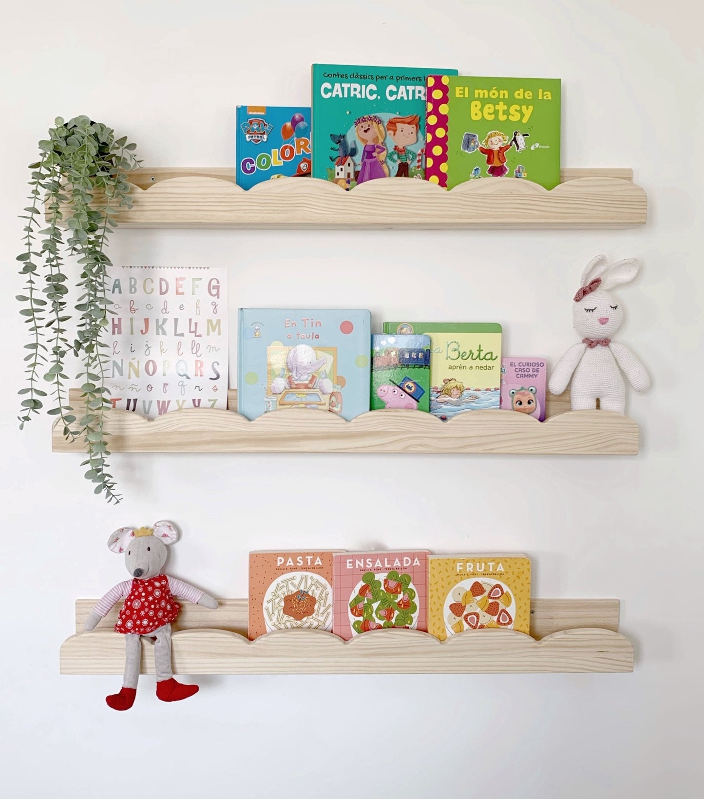 Estantería de madera clara con libros infantiles coloridos y juguetes suaves en estilo moderno y acogedor.