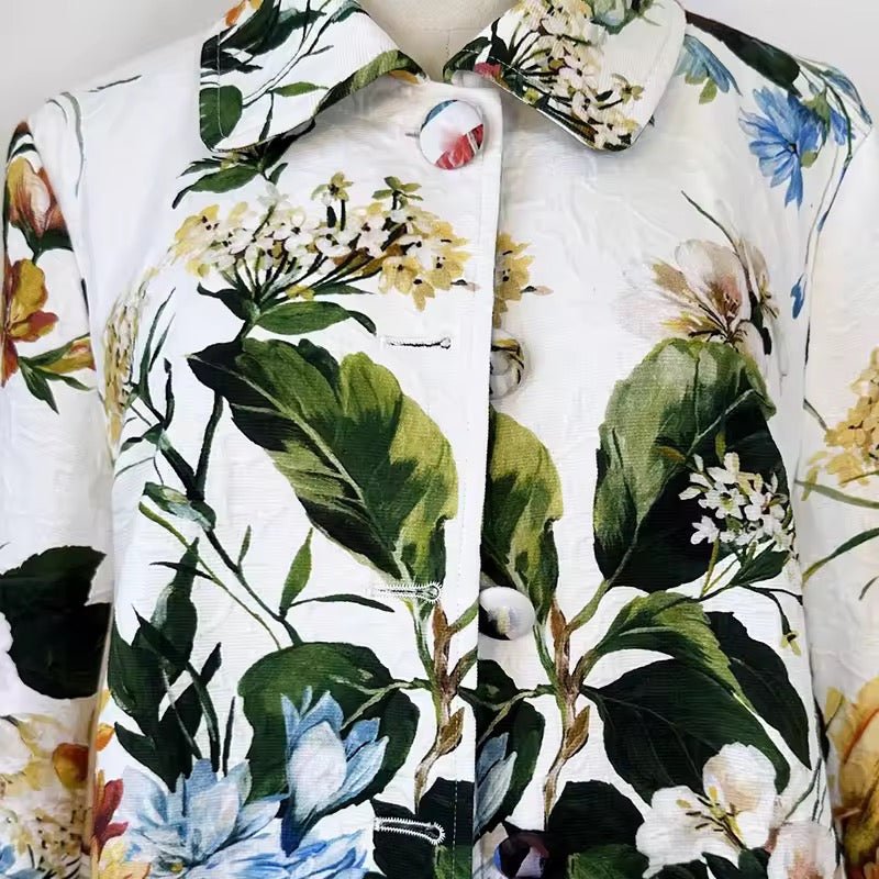 White long jacket in textured brocade featuring a vibrant, multi-colored floral print and fabric-covered buttons.