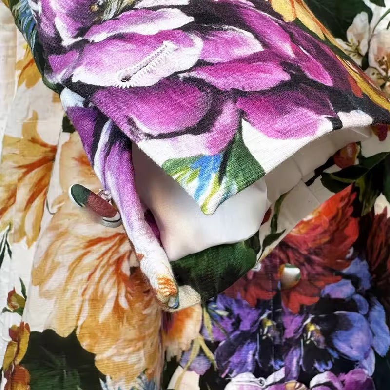 Floral print long brocade jacket with vibrant purple, yellow, and red flowers, white lining, and button closure.
