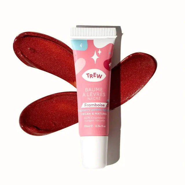 Tube de baume à lèvres nacré Trew framboise sur deux larges traces de matière rouge brillante et scintillante.