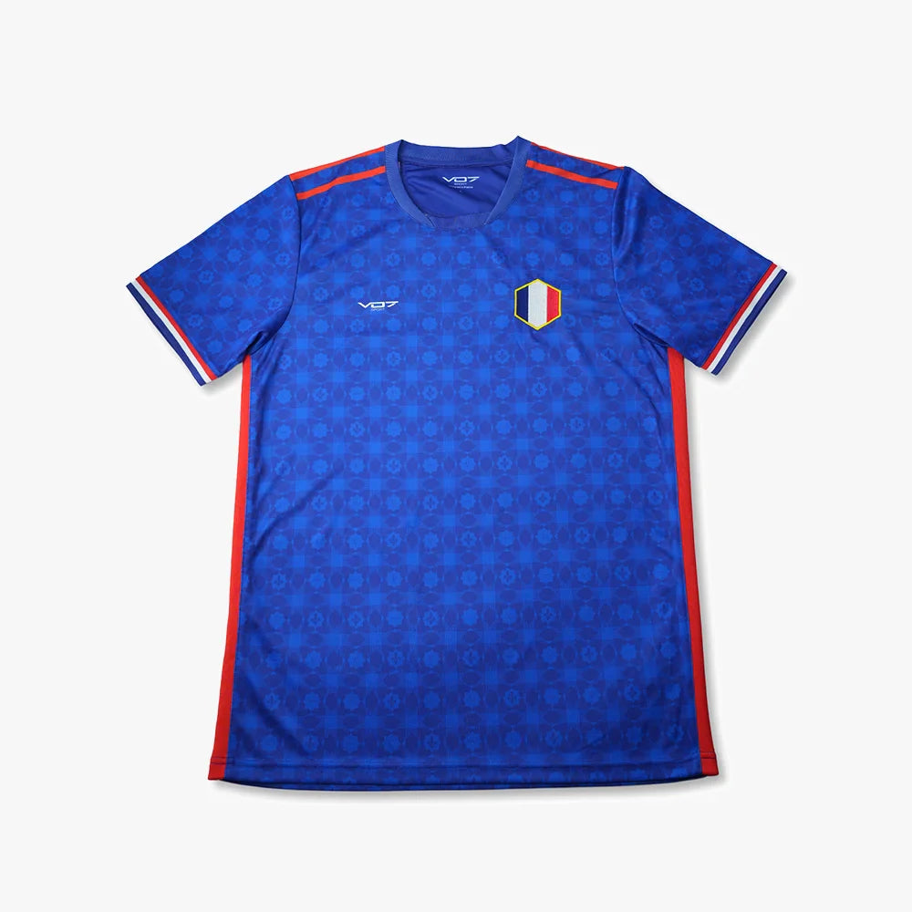 Maillot bleu VO7 à motif géométrique, col rond, détails tricolores aux manches et bandes rouges sur les côtés.
