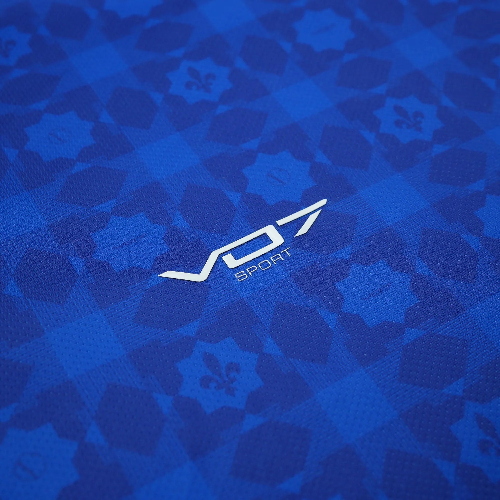 Maillot bleu VO7 en tissu technique, orné d'un motif géométrique en ton sur ton avec le logo blanc centré.