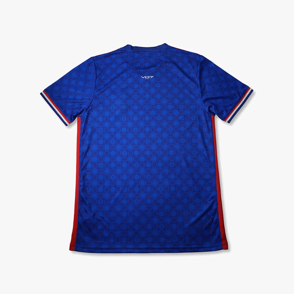 Maillot bleu VO7 à motif géométrique ton sur ton, logo blanc, détails bleu-blanc-rouge aux manches et bandes latérales.