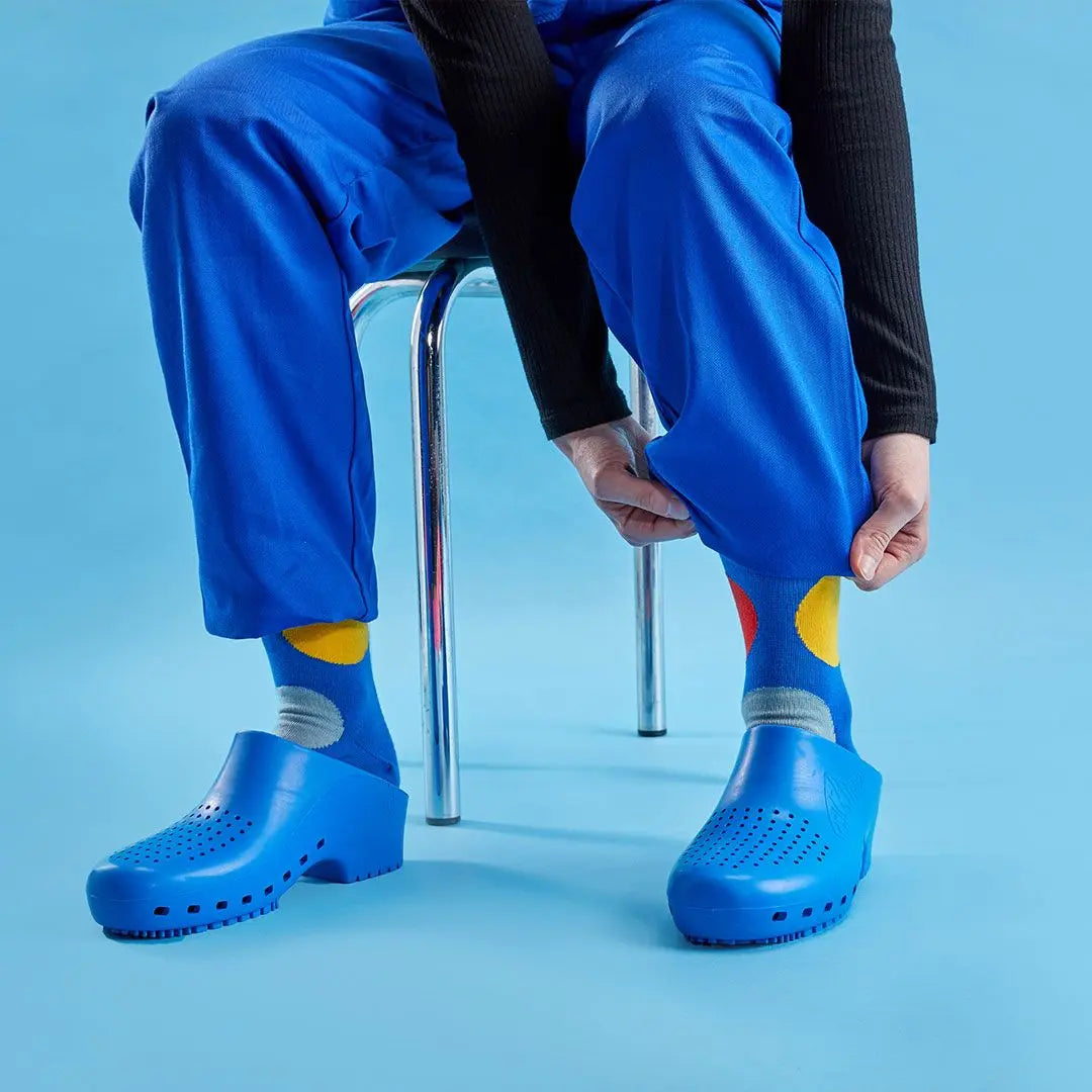 Royal blue clogs with ventilation holes, featuring a round toe, low heel, and minimalist rubberized construction.
