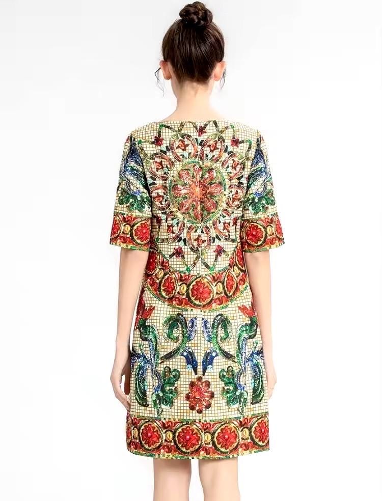 Colorful embroidered short dress with intricate floral patterns, featuring a mix of red, green, and gold hues.