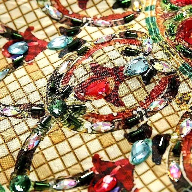 Colorful beaded fabric with red, green, and blue gems, featuring intricate patterns on a beige background.