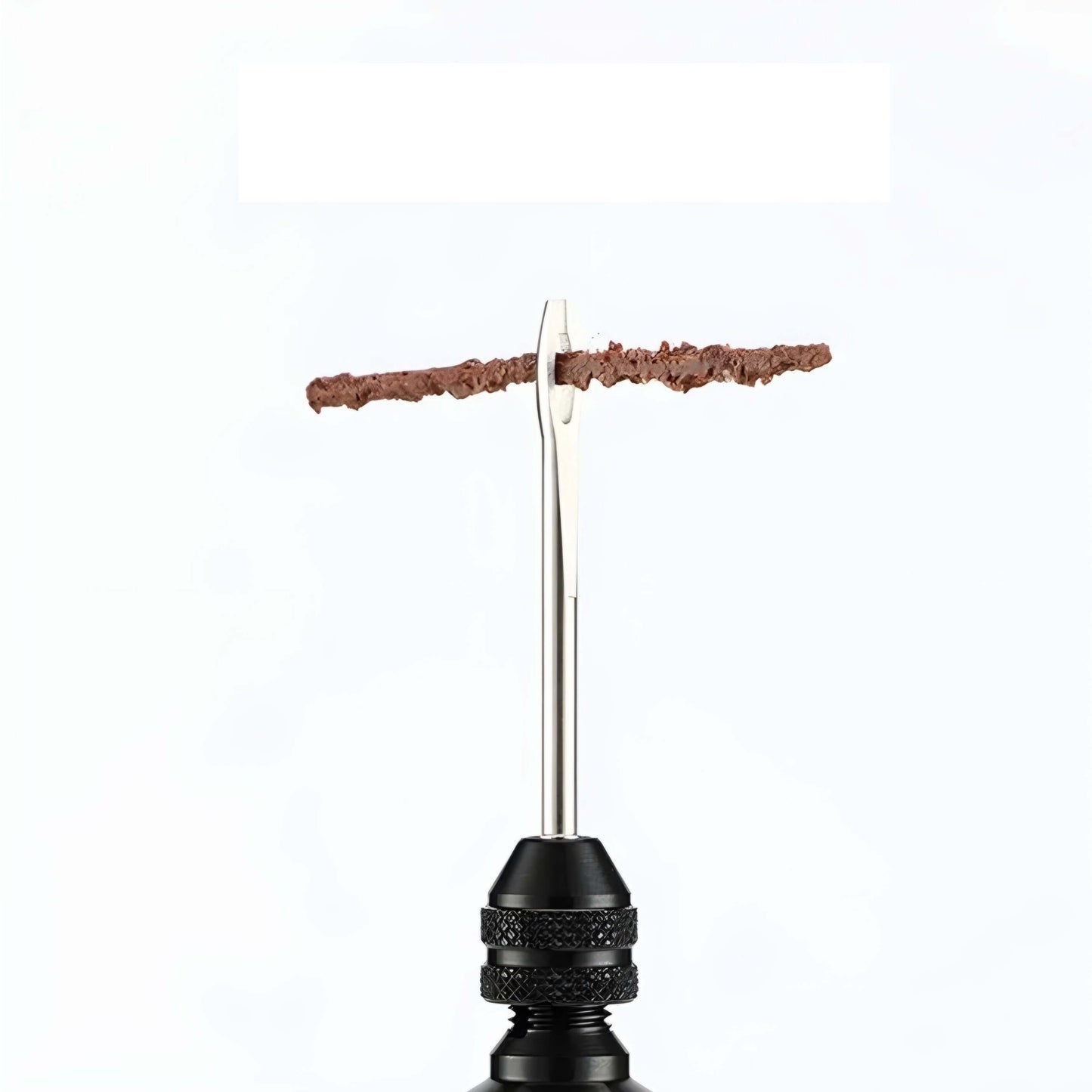 Detalle de herramienta de kit repara pinchazos con mecha marrón instalada para reparación