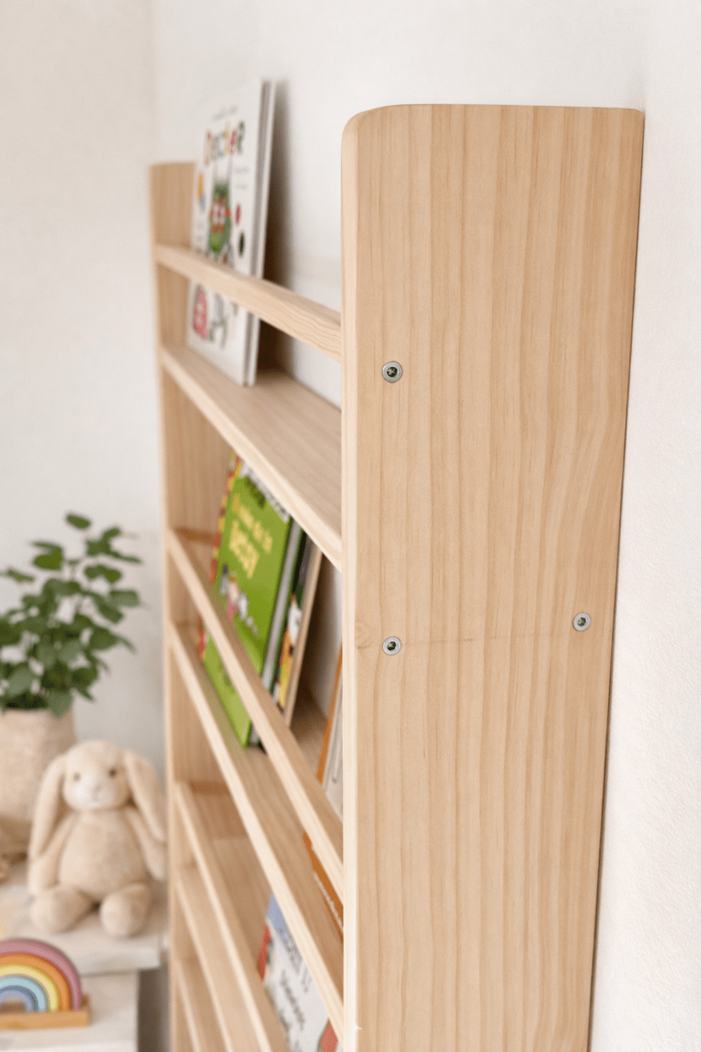 Estantería de madera clara con estantes rectos, ideal para almacenar libros y decorar el cuarto infantil.