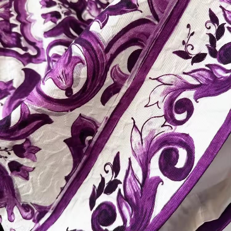 Purple floral patterned fabric with intricate designs on a white background, ideal for elegant fashion and home decor.