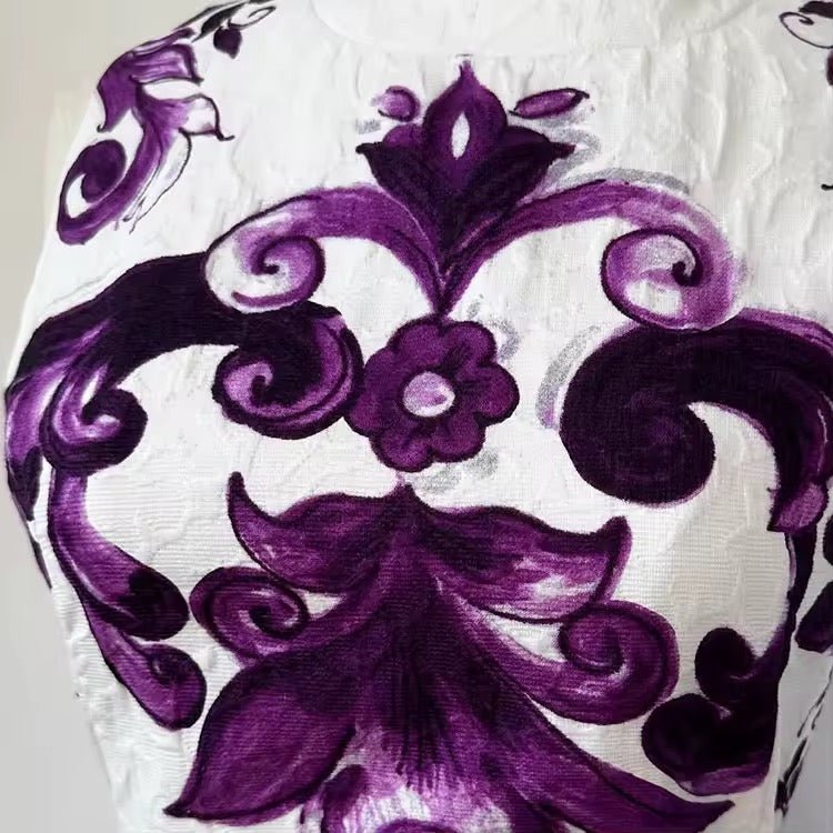 Elegant white fabric with intricate purple floral patterns, perfect for chic home decor or fashion projects.