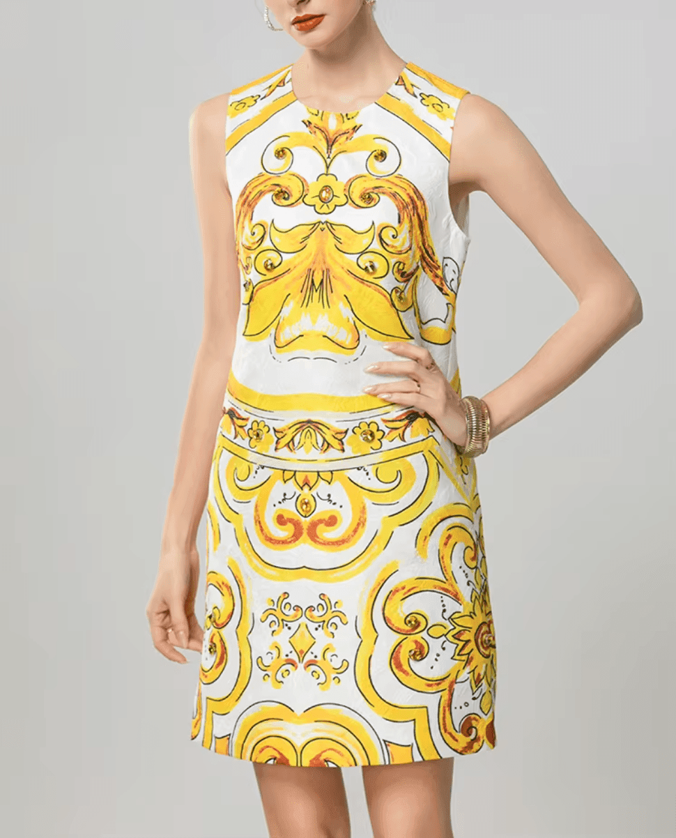 Sleeveless white dress with vibrant yellow baroque print, perfect for summer events and stylish casual outings.