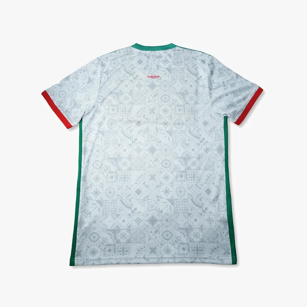 Maillot VO7 blanc à motifs azulejos gris, col et bandes latérales verts, finitions rouges aux manches. Dos technique.