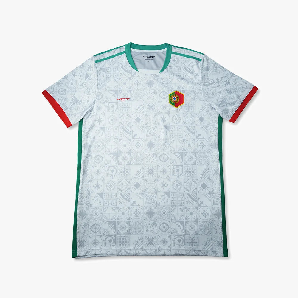 Maillot blanc VO7 à motifs azulejos, col et bandes latérales verts, finitions rouges aux manches et écusson du Portugal.