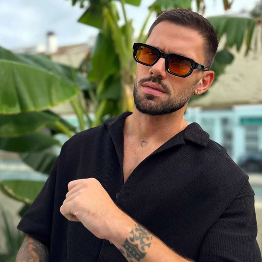 Hombre con gafas de sol negras lentes naranjas UV400 estilo moderno casual exterior