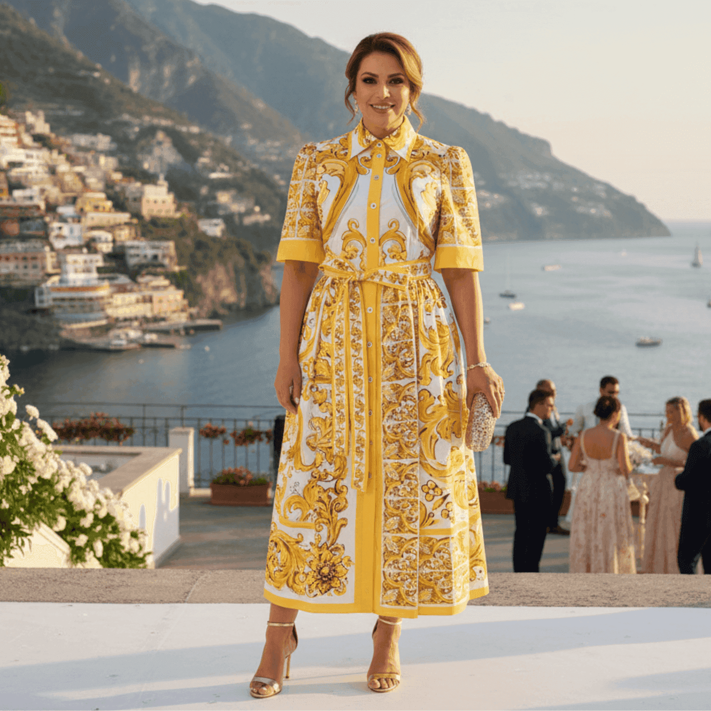 Yellow floral print maxi dress with puff sleeves and belt, perfect for summer events against a scenic coastal backdrop.