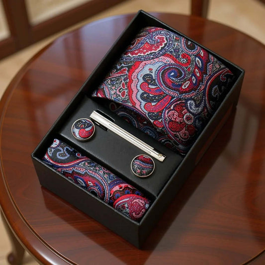 Set de corbata, pañuelo y gemelos con estampado paisley en tonos azul y morado, elegante y detallado en caja de regalo.