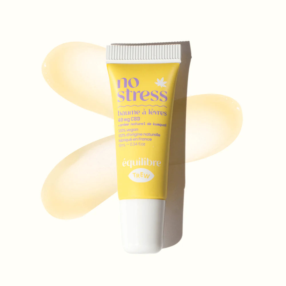 A yellow squeeze tube of lip balm with purple text, placed over a smear of translucent, light yellow balm.