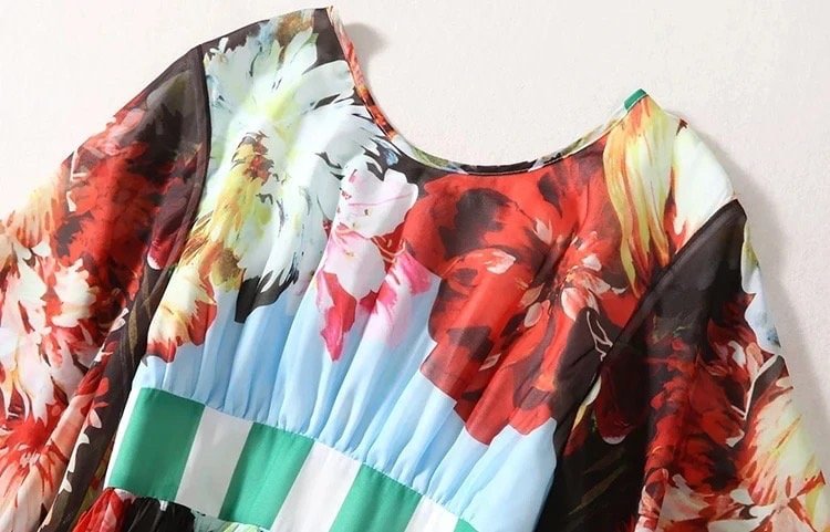 Colorful floral-print dress featuring red, blue, and green hues with a flowing silhouette and soft fabric.