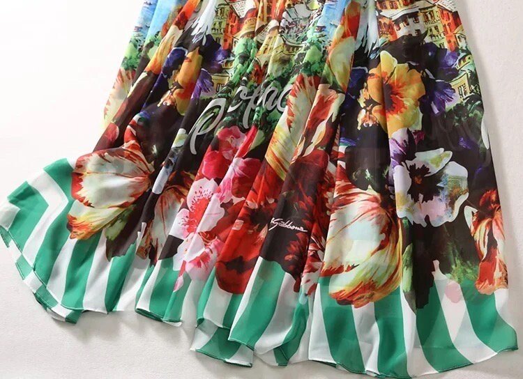 Colorful floral print maxi dress with green and white striped hem, crafted from lightweight chiffon fabric.