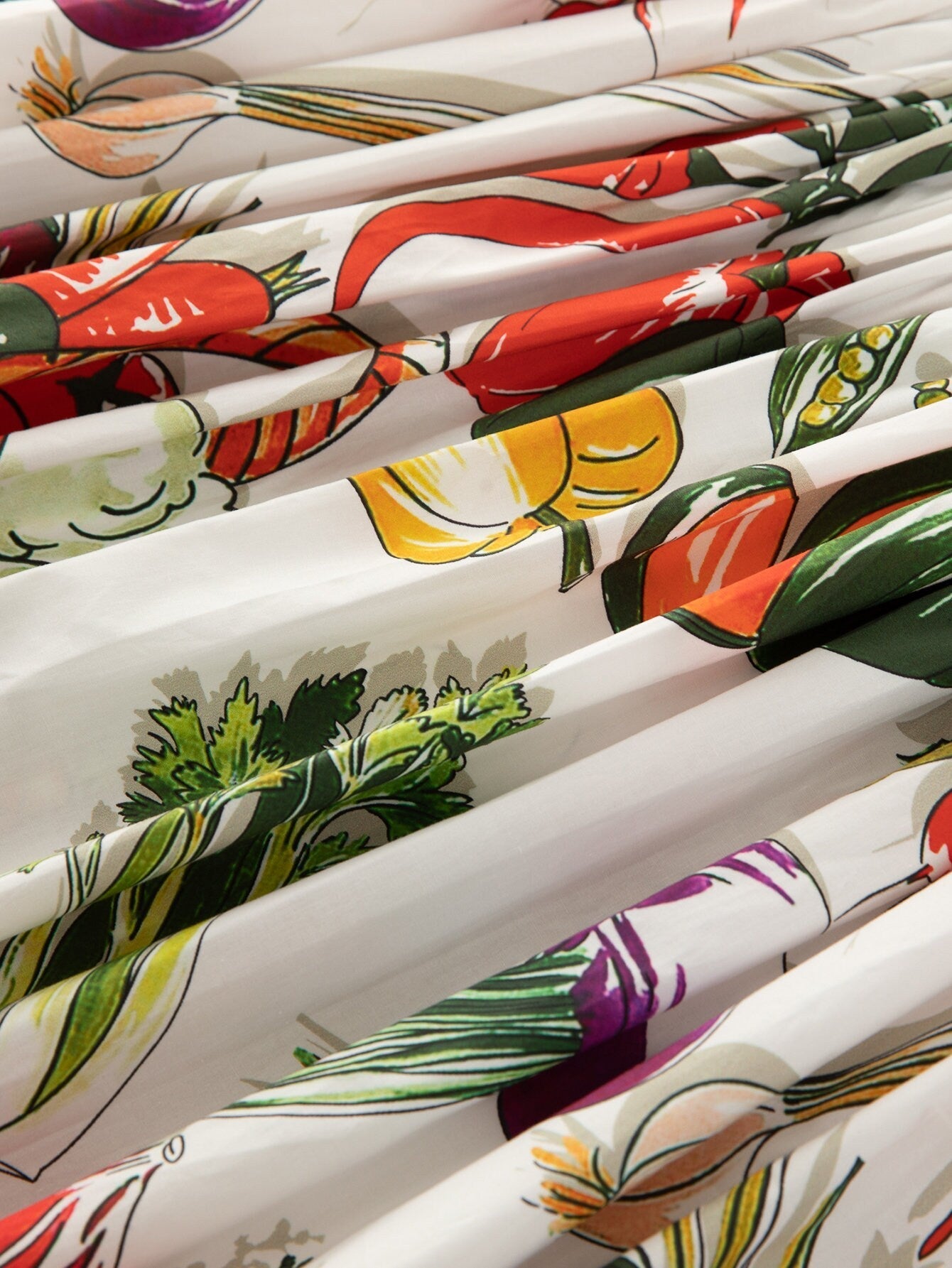 Floral printed fabric featuring colorful vegetables on a white background, ideal for lively home décor projects.