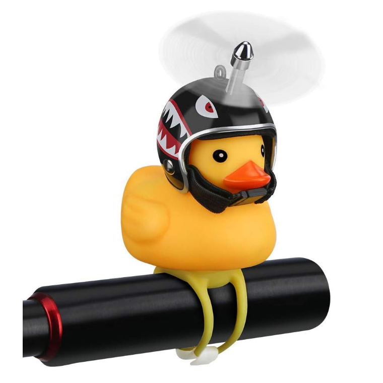 Yellow rubber duck wearing a black shark helmet and spinning propeller, perched on a black toy rocket.