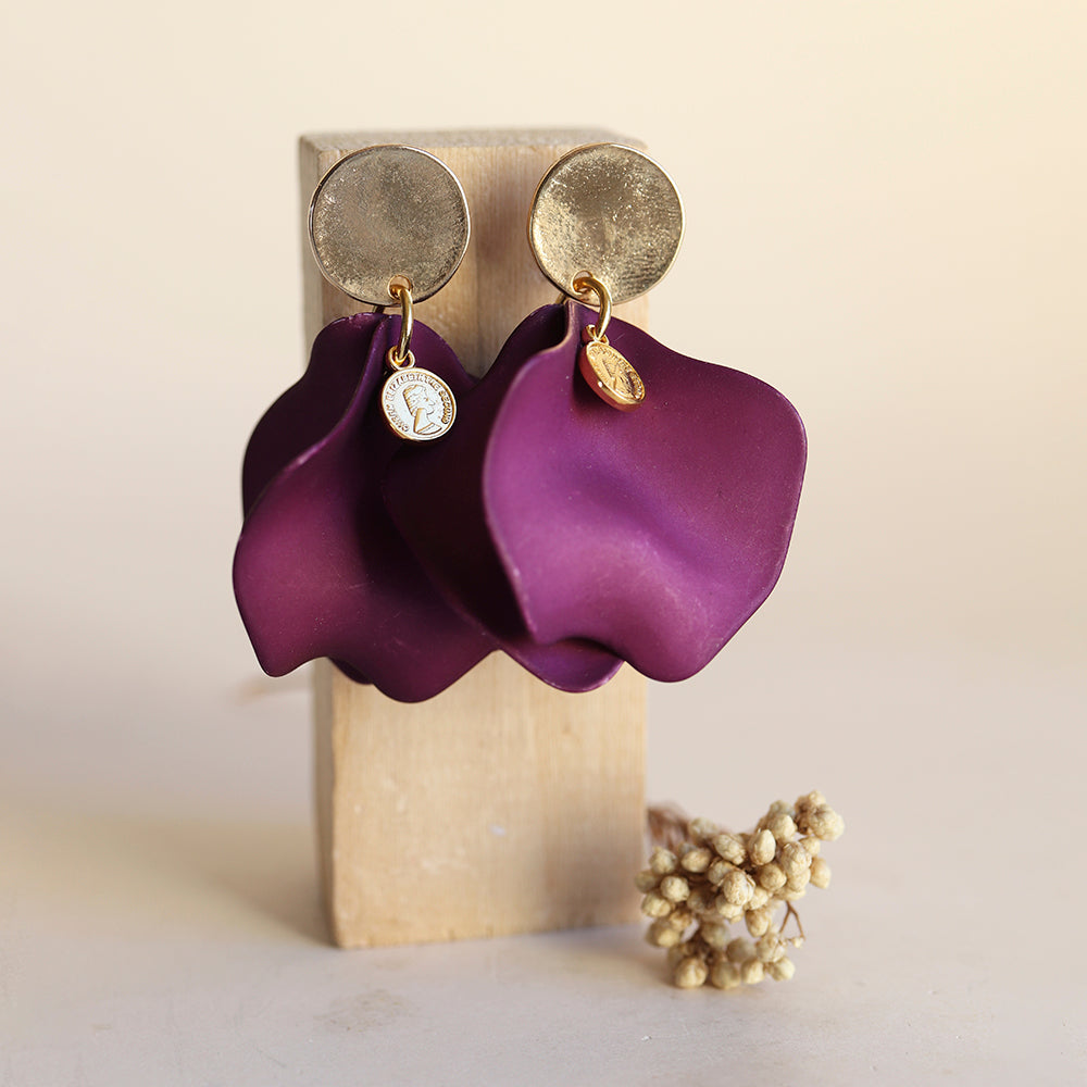 Pendientes grandes de cerámica morada con detalles dorados, estilo moderno y elegante.