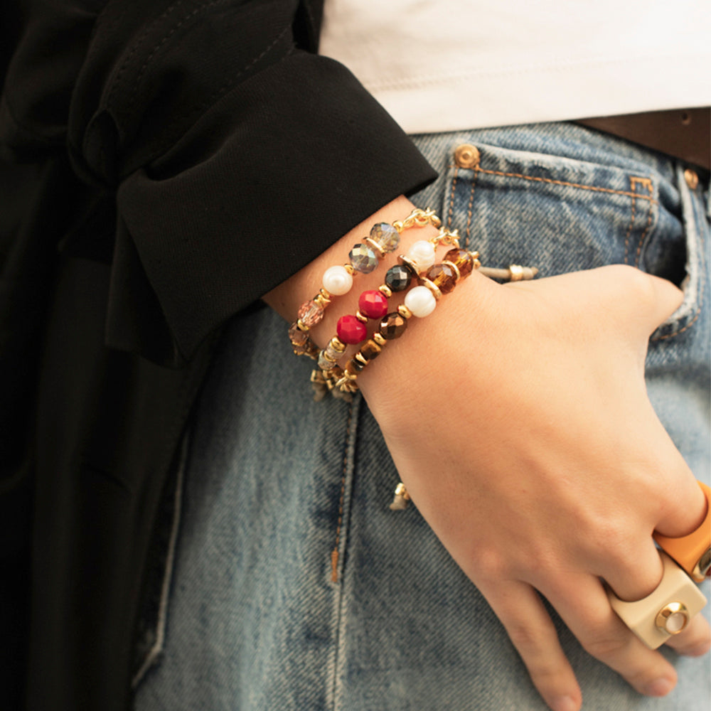 Pulsera de cuentas en tonos rojo, dorado y azul, estilo bohemio, con detalles en perlas y piedras preciosas.