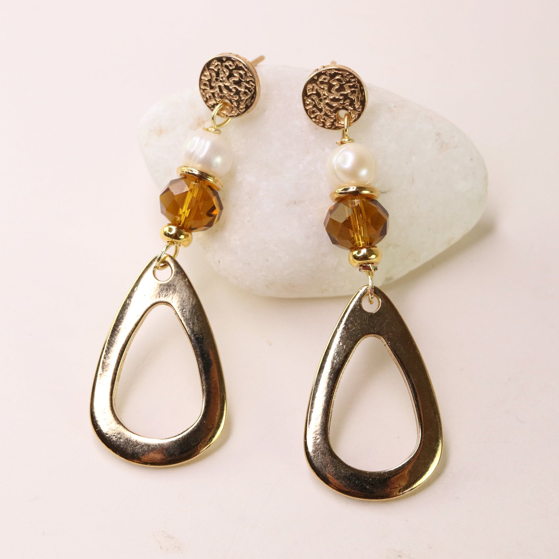 Pendientes dorados con perlas y cristales ámbar, estilo moderno y elegante. Perfectos para ocasiones especiales.