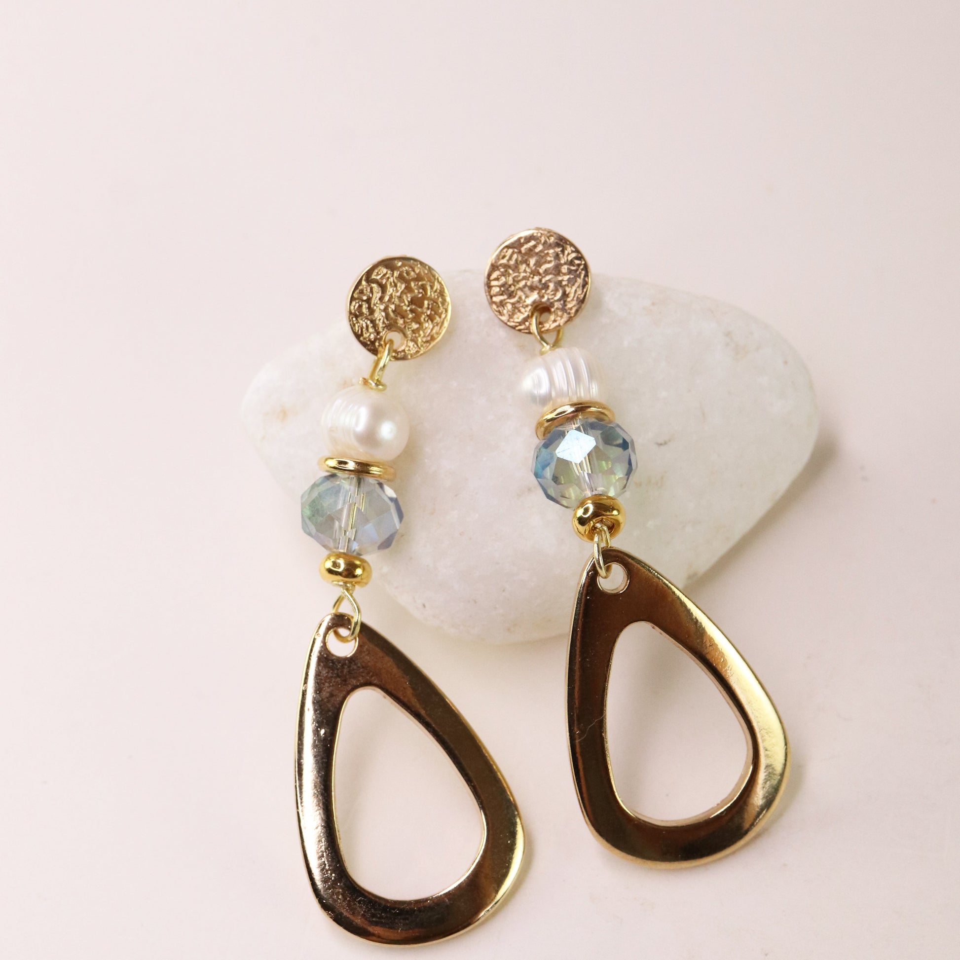 Pendientes dorados con cuentas de cristal azul y perlas, diseño moderno y elegante, perfectos para ocasiones especiales.