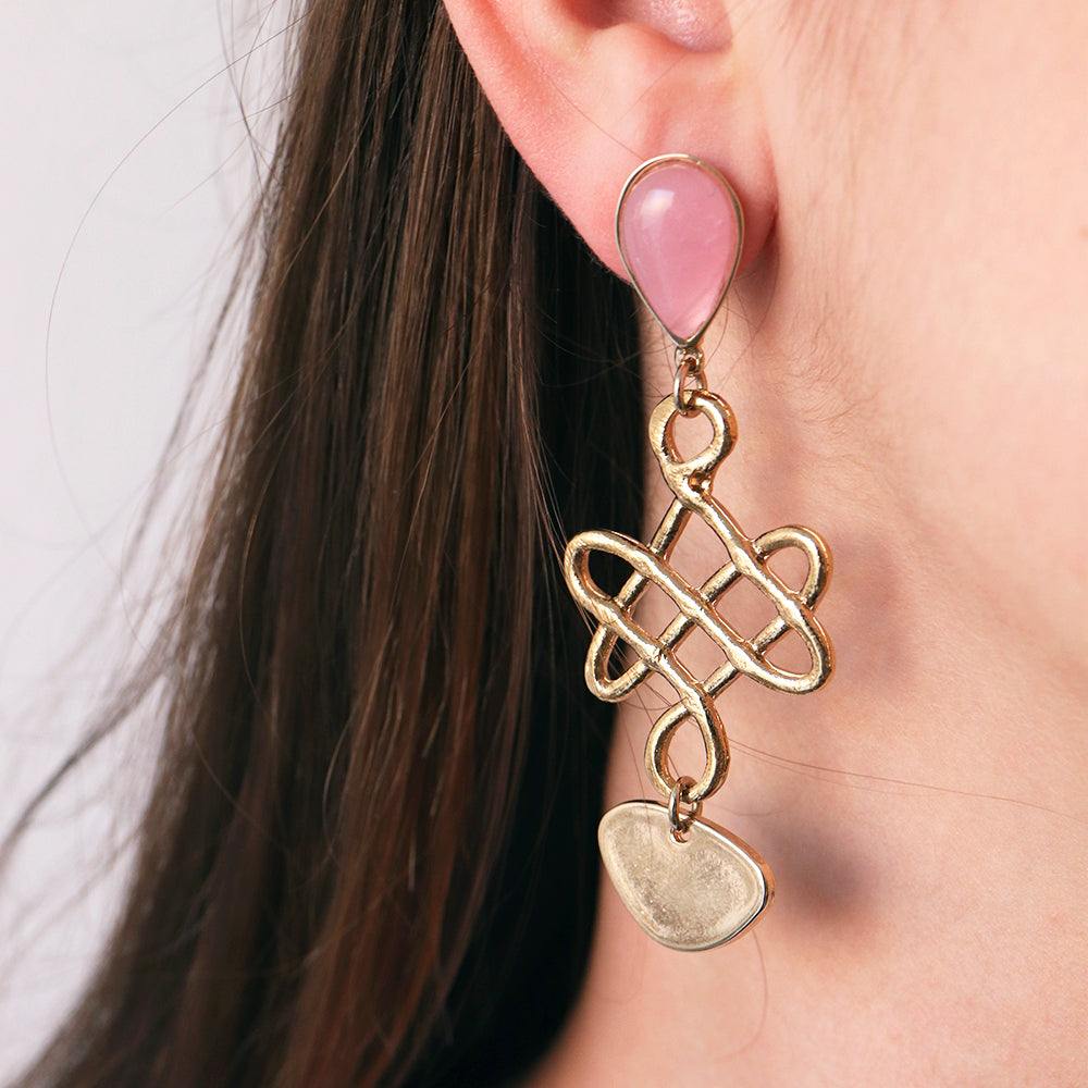Pendientes de oro con forma de lazo y piedras rosas, elegantes y modernos, ideales para ocasiones especiales.