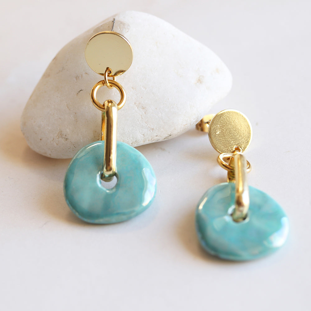 Pendientes de cerámica turquesa con detalles dorados, estilo moderno y elegante, perfectos para cualquier ocasión.