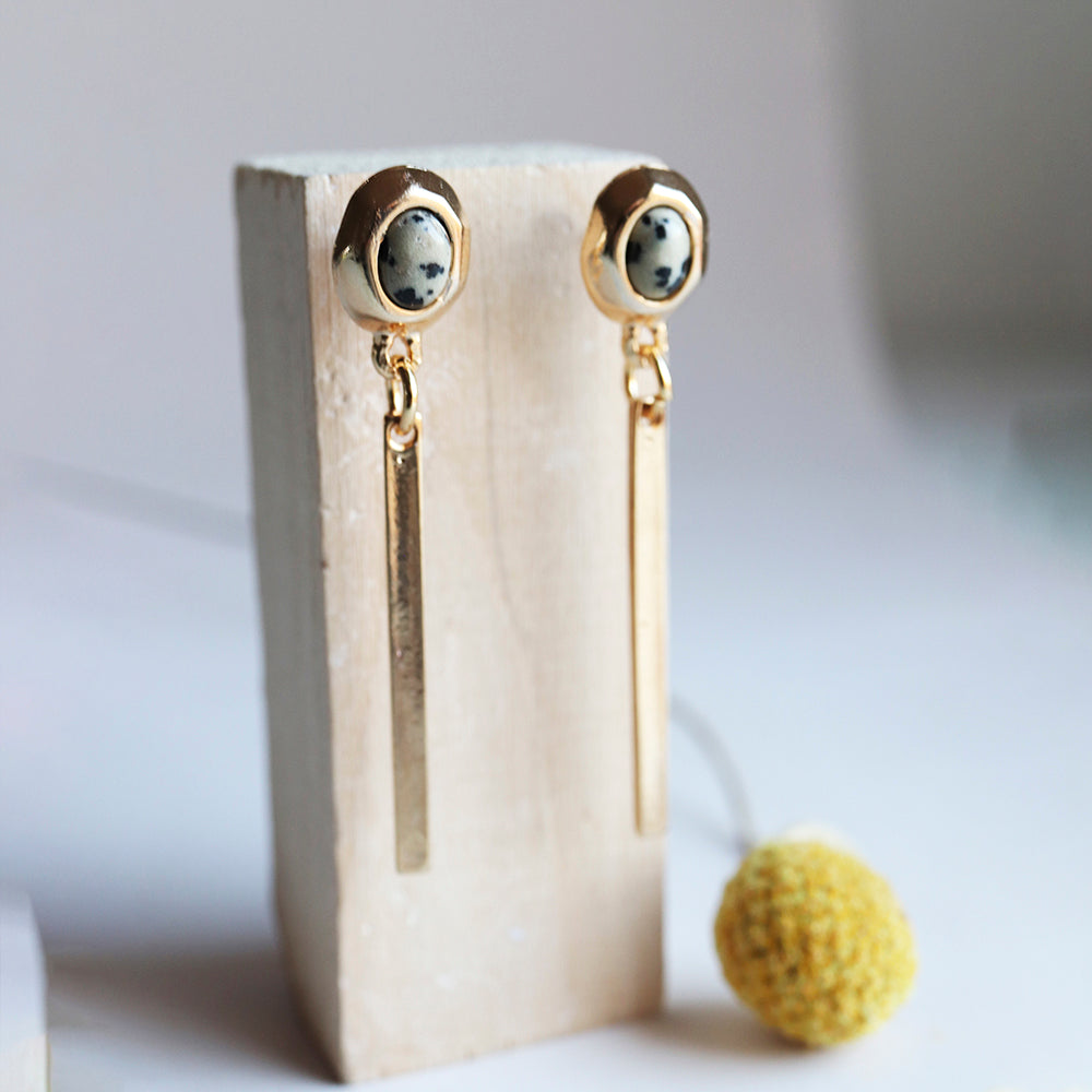 Pendientes largos dorados con ónix blanco y negro, estilo moderno y elegante, perfectos para cualquier ocasión.