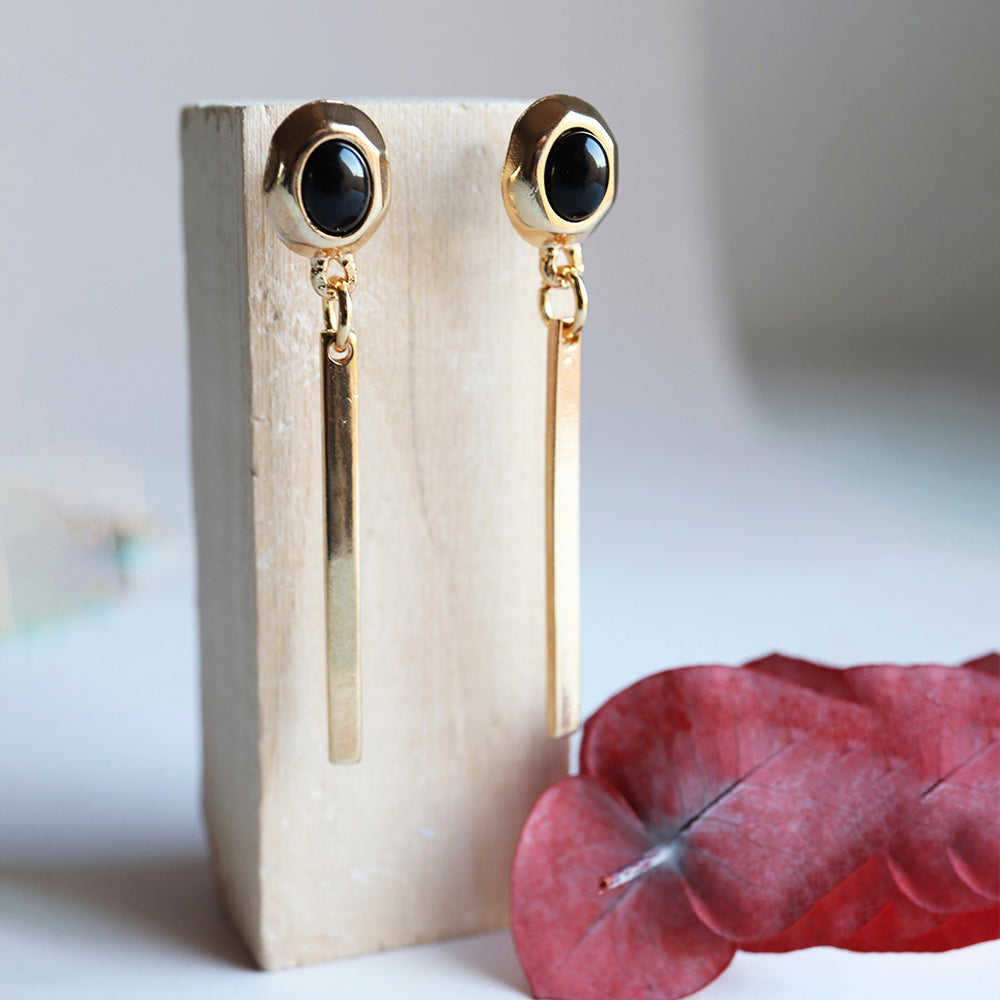 Pendientes largos de oro con ónix negro, estilo elegante y moderno, perfectos para ocasiones especiales.