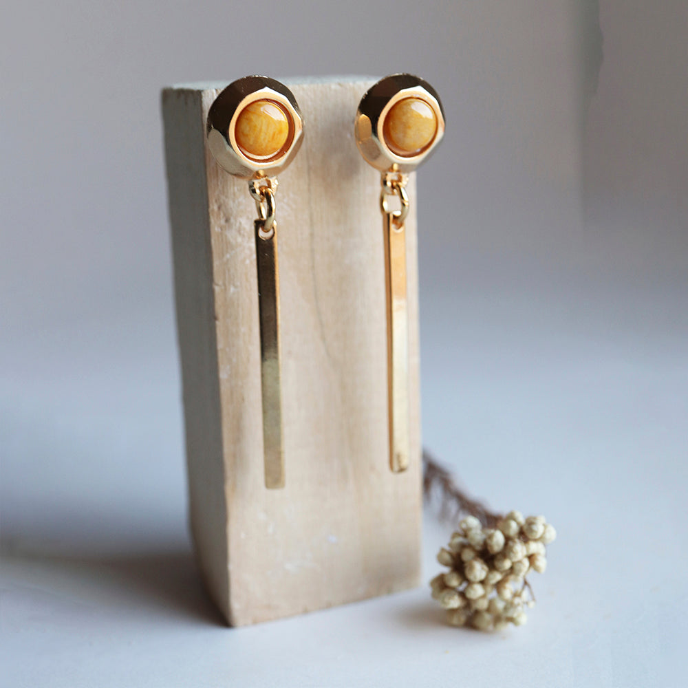 Pendientes dorados con detalle de madera y barra larga, diseño elegante y moderno. Ideal para cualquier ocasión.