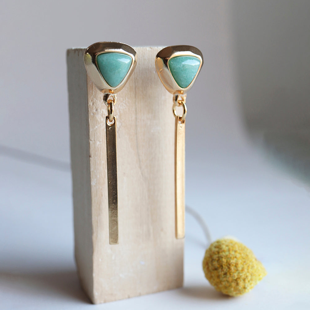 Pendientes dorados con agujas y piedra verde, estilo moderno y elegante, perfectos para cualquier ocasión.
