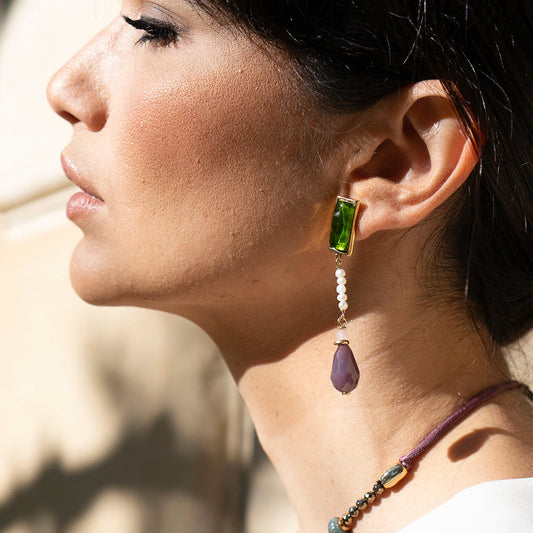 Pendientes largos de oro con piedra verde y morada, cuentas blancas y estilo elegante.