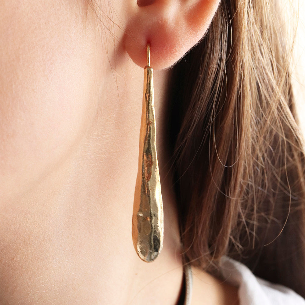 Pendientes largos de oro, diseño moderno y texturizado, perfectos para realzar cualquier atuendo elegante.